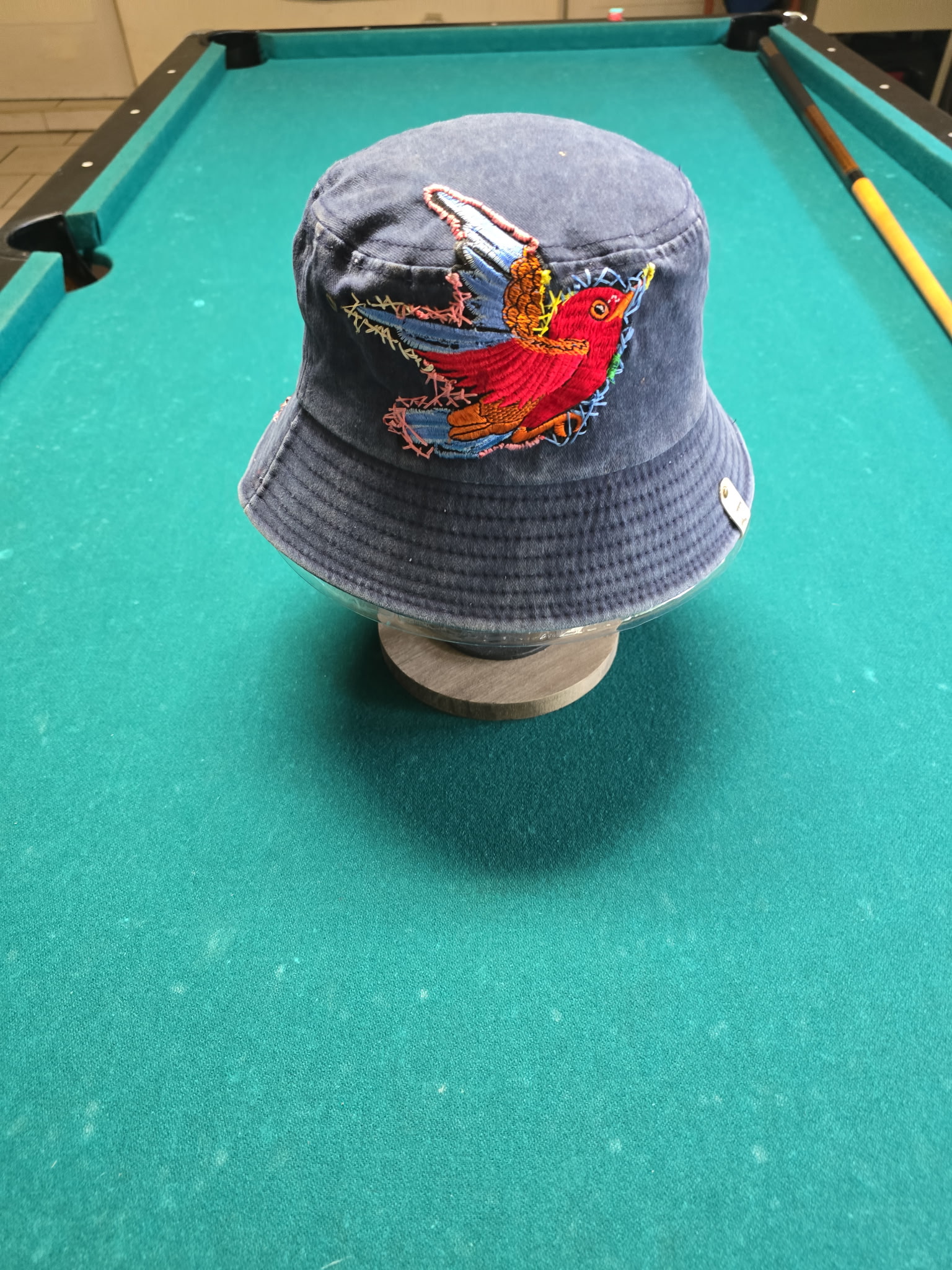 Navy bucket hat hand-embroidered with a full wingspan red bird