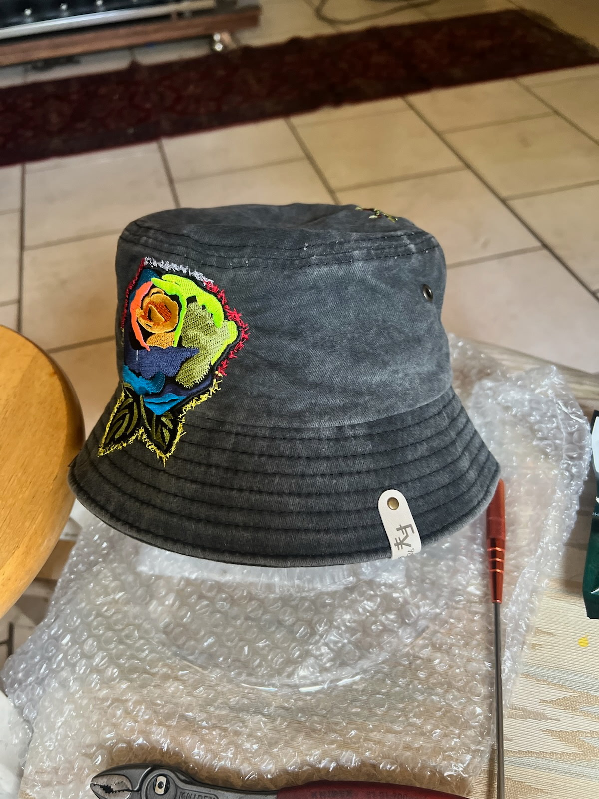Charcoal bucket hat hand-embroidered with a multicolor rose